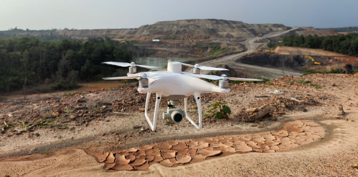 Drone capturing high-resolution aerial mapping data over large infrastructure site for design and construction planning